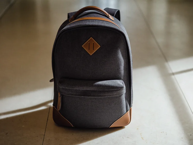 Rucsac urban antracit cu detalii din piele, pe pardoseală de piatră deschisă